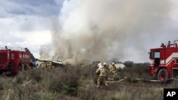 Rescue workers and firefighters are seen at the site where an Aeromexico airliner has suffered an "accident" in a field near the airport of Durango, Mexico, Tuesday, July 31, 2018. (Civil Defense Office of Durango Photo via AP)