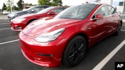 FILE - 2018 Model 3 sedans sit on display outside a Tesla showroom in Littleton, Colo., US.