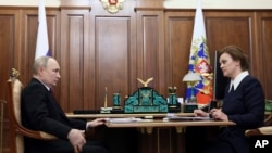 Presiden Rusia Vladimir Putin berbicara dengan Anna Tsivileva, putri mendiang sepupu Putin, yang hari Senin (17/6) diangkat sebagai salah satu Deputi Menhan Rusia (foto: dok). 