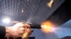 FILE - A semiautomatic pistol with a conversion device installed making it fully automatic is fired as four empty shell casings fly out of the weapon, at the Bureau of Alcohol, Tobacco, Firearms, and Explosives National Services Center, March 2, 2023, in Martinsburg, W.Va. 