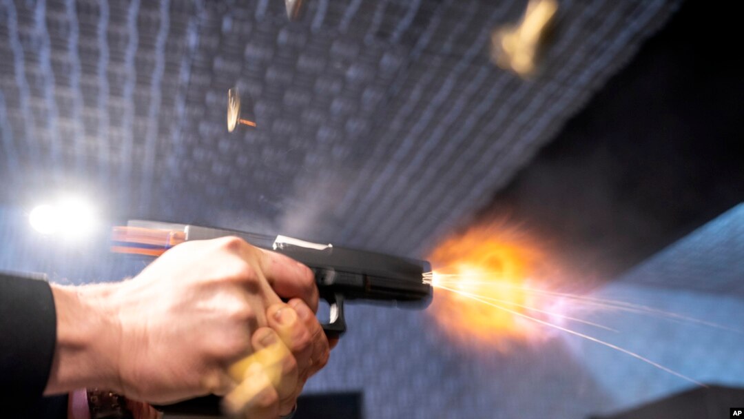 FILE - A semiautomatic pistol with a conversion device installed making it fully automatic is fired as four empty shell casings fly out of the weapon, at the Bureau of Alcohol, Tobacco, Firearms, and Explosives National Services Center, March 2, 2023, in Martinsburg, W.Va. 