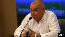 FILE - Dmitry Kiselyov, head of the official Russian state news agency Rossiya Segodnya, gestures during a press conference in Moscow on May 26, 2014.