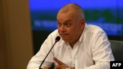 FILE - Dmitry Kiselyov, head of the official Russian state news agency Rossiya Segodnya, gestures during a press conference in Moscow on May 26, 2014.