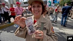 Una miembro de la milicia chavista muestra un billete de muestra con la imagen del presidente de la Asamblea Nacional, el opositor Henry Ramos Allup, durante una marcha de apoyo a gobierno.