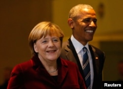 U.S. President Barack Obama walks with German Chancellor Angela Merkel as they arrive for a joint news conference in Berlin, Germany, Nov. 17, 2016.