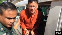 Ny Chakrya, National Election Committee officer, escorted by the security officers at the appeal court, Phnom Penh, Cambodia, November 28, 2016. (Photo: Kann Vicheika/VOA Khmer)