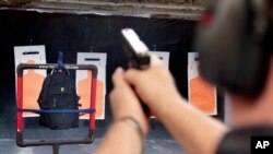 Steve Naremore, founder and CEO of TuffyPacks, fires nine rounds of 180 grain .40 S&W from his Glock handgun into a backpack seven yards away containing one of his bulletproof inserts, made of layers of Aramid fiber ballistic material providing…