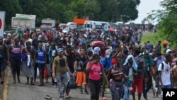 Migrantes centroamericanos, africanos y caribeños caminan por la Autopista 200 en ruta a Huxtla, cerca de Tapachula, estado de Chiapas, en México. Partieron de Tapachula a pie el sábado con miras a llegar a EE.UU. 12 de octubre de 2019. AP/Isabel Mateos.