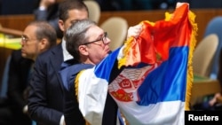 Predsjednik Srbije Aleksandar Vučić drži zastavu Srbije u Generalnoj skupštini Ujedinjenih nacija na sjednici na kojoj se glasalo o rezoluciji o genocidu u Srebrenici (REUTERS/Eduardo Munoz)