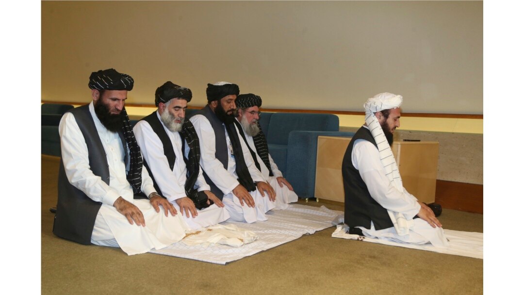 La delegación talibán de Afganistán reza antes de la firma del acuerdo entre talibanes y funcionarios estadounidenses en Doha, Catar, el sábado 29 de febrero de 2020.