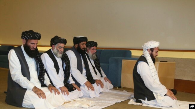 La delegación talibán de Afganistán reza antes de la firma del acuerdo entre talibanes y funcionarios estadounidenses en Doha, Qatar,.