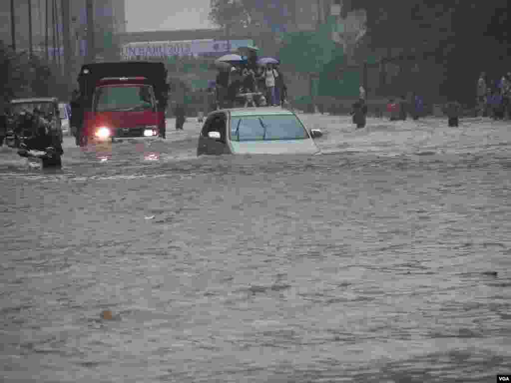 A car tries to drive through Jakarta's flooded streets, Indonesia, January 17, 2013. (VOA Indonesian Service)