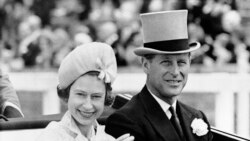 FILE - In this June 19, 1962 file photo, Britain's Queen Elizabeth II and Prince Philip travel by open carriage around the track prior to the race program, at Ascot, England.