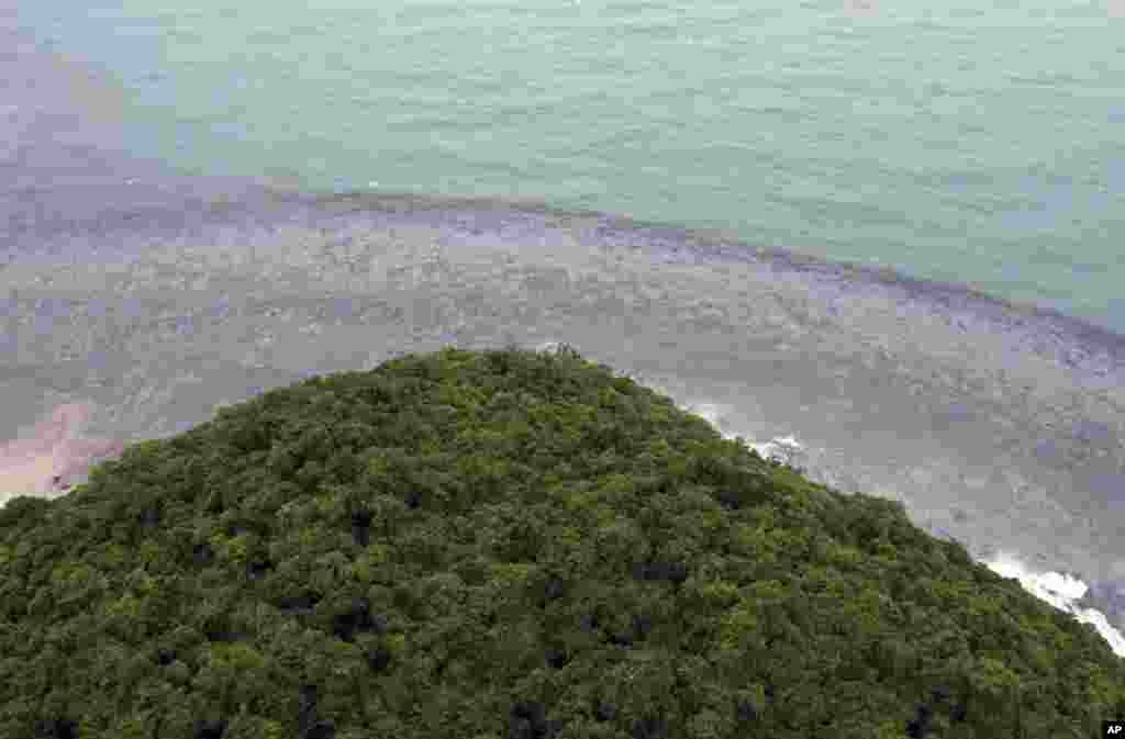 Streaks of crude oil are seen on the shore of Prao Bay on Samet Island, Thailand, July 29, 2013. 