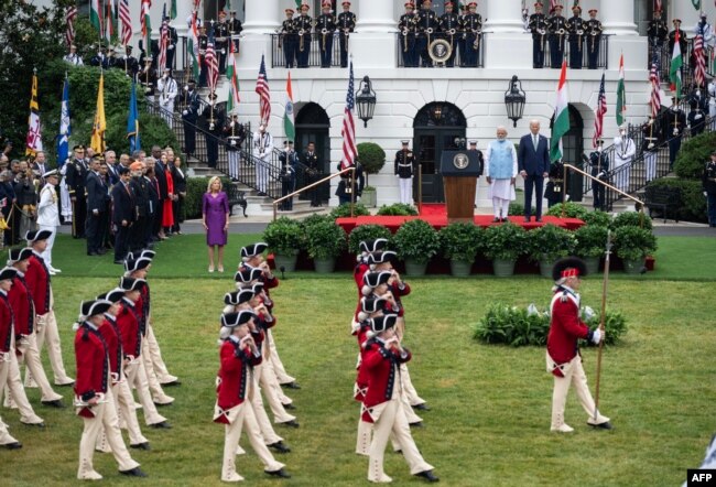 US President Joe Biden and India's Prime Minister Narendra Modi, with First Lady Jill Biden (L), watch the Fife and Drum Corps perform during a welcoming ceremony for Modi in the South Lawn of the White House in Washington, DC, on June 22, 2023. (Photo by ANDREW CABALLERO-REYNOLDS / AFP)