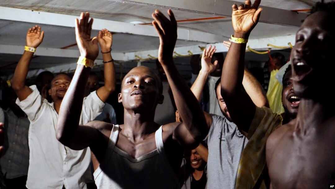 Para migran di kapal Open Arms merayakan berita bahwa mereka akhirnya diperbolehkan berlabuh di Pulau Lampedusa, selatan Italia, 20 Agustus 2019. 