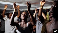 Migrants onboard the Open Arms vessel celebrate the news of an Italian prosecutor who has ordered that the migrants be disembarked on the island of Lampedusa, southern Italy, Aug. 20, 2019. 