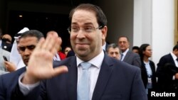 FILE - Tunisia's Prime Minister Youssef Chahed gestures after a meeting of the Islamic Development Bank Group in Tunis, Tunisia, April 4, 2018.
