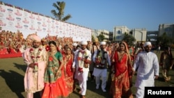 Brides and grooms arrive to take their wedding vows during a mass marriage ceremony, in which 261 including six Muslim and three Christian couples took their wedding vows, in Surat, Gujarat, India.