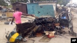 Warga memeriksa lokasi ledakan bom mobil di Maiduguri, Nigeria, Rabu (12/10).