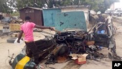 Des Badauds se rassemblent sur le lieu d’un attentat à la voiture piégée à Miaduguri, Nigeria, 12 octobre 2018.