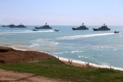 FILE - This handout photo released April 22, 2021, by Russia's Defense Ministry shows Russian navy ships preparing to unload troops during drills in Crimea, a peninsula Russia annexed from Ukraine in 2014.