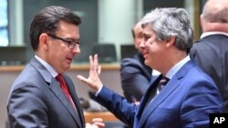 Portuguese Economy Minister and chief of the Eurogroup Mario Centeno, right, speaks with Spanish Economy, Industry and Competitiveness Minister, Roman Escolano during a meeting of the Eurogroup at the EU Council building in Brussels, March 12, 2018.