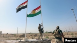 A member of Iraqi security forces takes down the Kurdish flag in Kirkuk, Iraq October 16, 2017. (REUTERS/Stringer)