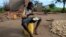 Bernado Jofresse, 14, eats rice for breakfast as he sits beside his family's damaged house in the aftermath of Cyclone Idai, in the village of Cheia, which means "Flood" in Portuguese, near Beira, Mozambique, April 3, 2019.