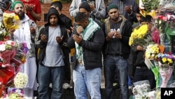 A man reacts during prayers at the scene where three South Asian men were killed by a car during the recent rioting in Birmingham, England, August 11, 2011