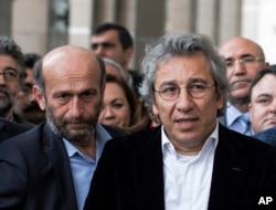 FILE - Can Dundar, right, the editor-in-chief of opposition newspaper Cumhuriyet, and Erdem Gul, left, the paper's Ankara representative, speak to the media outside a courthouse in Istanbul, Turkey, Nov. 26, 2015.