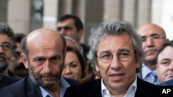 Can Dundar, right, the editor-in-chief of opposition newspaper Cumhuriyet, and Erdem Gul, left, the paper's Ankara representative, speak to the media outside a courthouse in Istanbul, Turkey, Nov. 26, 2015.