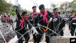 Thai police remove barbed wire outside the city police headquarters in Bangkok, Thailand, Dec. 3, 2013.