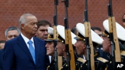 FILE - Uzbek President Islam Karimov (L) watches honor guards passing by during a wreath-laying ceremony at the Tomb of the Unknown Soldier by the Kremlin wall in Moscow, Russia, Apr. 26, 2016.