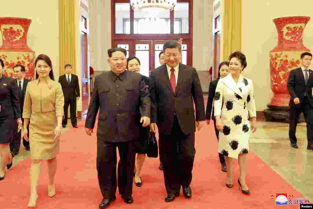 មេដឹកនាំកូរ៉េខាងជើងលោក Kim Jong Un និងភរិយារបស់លោក គឺលោកស្រី Ri Sol Ju ជាមួយលោកប្រធានាធិបតីចិន Xi Jinping និងភរិយារបស់លោក គឺលោកស្រី Peng Liyuan ដើរជាមួយគ្នាក្នុងទីក្រុងប៉េកាំងនៃប្រទេសចិន។ រូបថតនេះ មិនបានប្រាប់ពីថ្ងៃ ខែដែលបានថត ហើយចេញដោយទីភ្នាក់ងារព័ត៌មានកណ្តាលកូរ៉េរបស់កូរ៉េខាងជើងក្នុងទីក្រុងព្យុងយ៉ាង នៅថ្ងៃទី ២៨ ខែមីនា ឆ្នាំ២០១៨។
