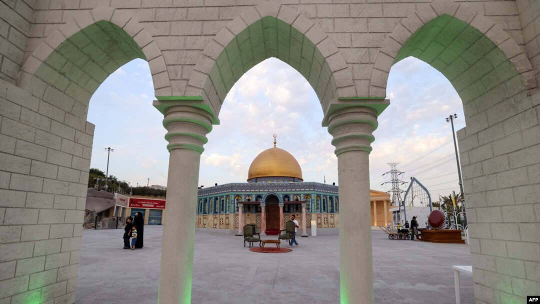 Visitors and staff walk near a scale model of Jerusalem's Al-Aqsa mosque at the Land of Civilizations art and culture show in Tehran, on August 11, 2024.