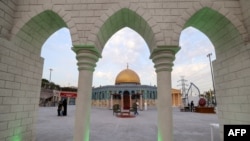 Visitors and staff walk near a scale model of Jerusalem's Al-Aqsa mosque at the Land of Civilizations art and culture show in Tehran, on August 11, 2024.