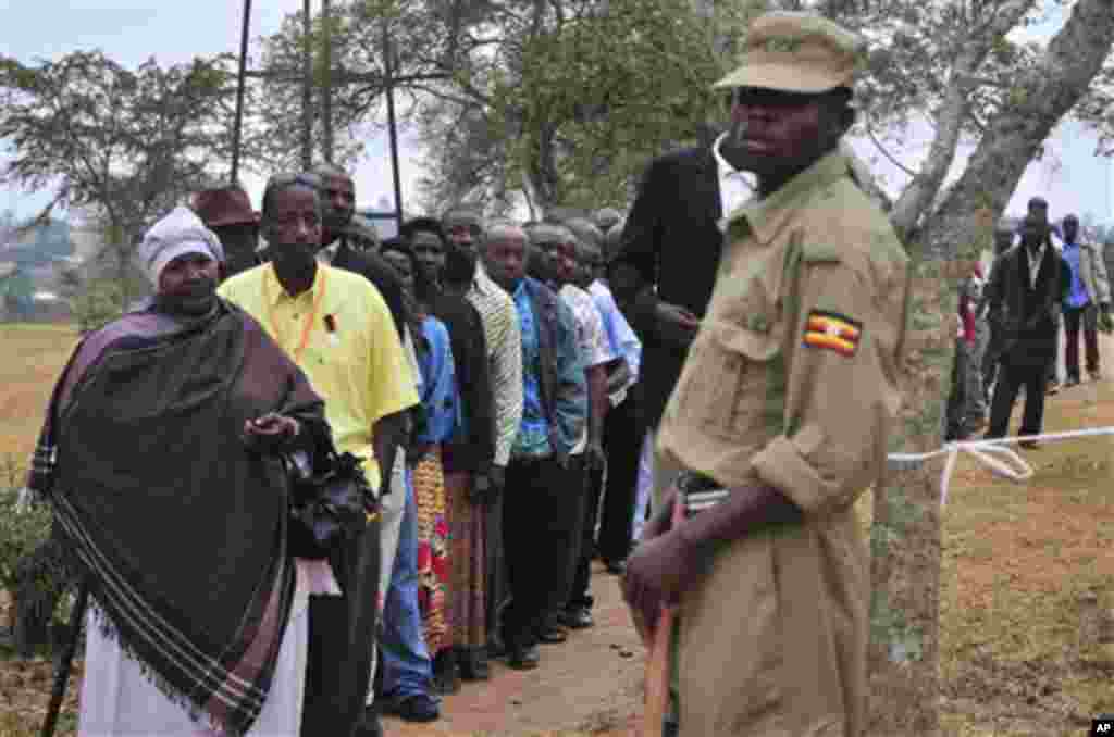 A Ugandan Police Officer provides security as voters wait to place their ballot, before voting begins in Rwakitura district, which is Museveni�s home area, at a Polling station about 300 Kms (200 miles) west of Kampala, Uganda, Friday, Feb. 18, 2011. Mi