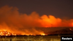 FILE - Smoke and flame rise from Park Fire burning near Chico, California, July 25, 2024. Picture taken with long exposure. 