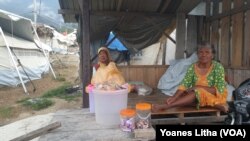 Dua lansia duduk menjaga barang dagangan mereka di shelter pengungsian di Balaroa, Kota Palu, Sulawesi Tengah. (Foto:VOA/Yoanes Litha)