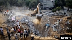 Palestinians gather as a bulldozer searches for victims amongst the rubble of a house, which police said was destroyed in an Israeli air strike, in Khan Younis in the southern Gaza Strip, July 21, 2014. 