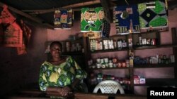 A Congolese woman stands inside her cosmetic shop in Bunagana near the Uganda-Democratic Republic of Congo border, July 9, 2012. 