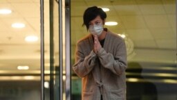 香港民主活动人士、歌手何韵诗获保释后走出警察局时向支持者鞠躬致谢。（2021年12月30日）