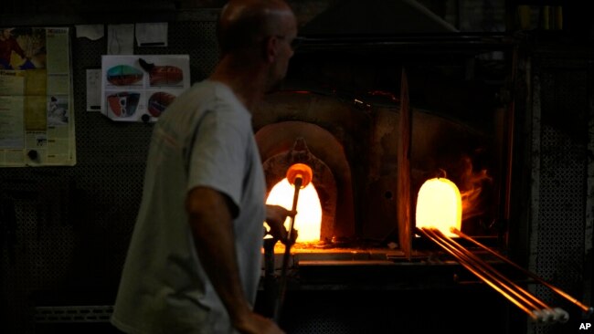 A glass-worker heats glass in a methane powered ovens in a factory in Murano island, Venice, Italy, Oct. 7, 2021.