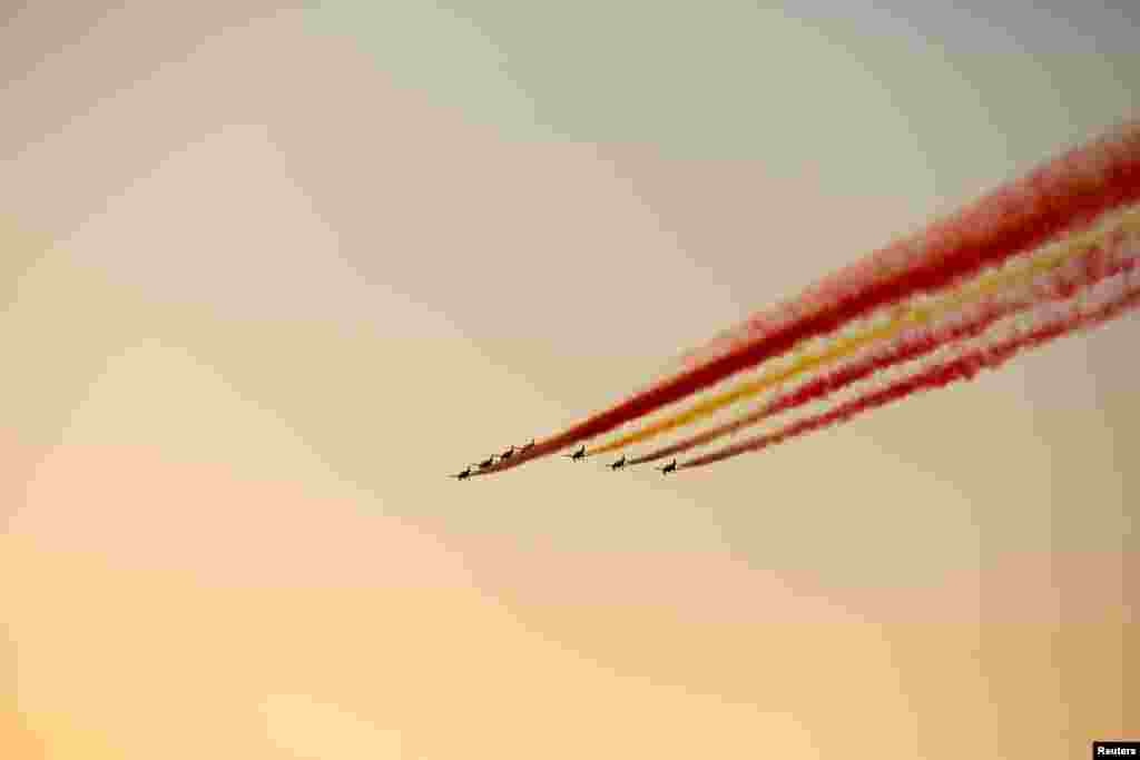 Spain's air force aerobatic team, Patrulla Aguila, flies by for the arrival of the solar-powered plane Solar Impulse 2, piloted by Swiss aviator Bertrand Piccard, in Seville, Spain.