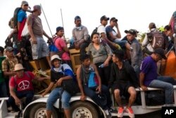 Central American migrants traveling with a caravan to the U.S. crowd onto a tractor as they make their way to Mapastepec, Mexico, Oct. 24, 2018.