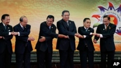 Brunei Sultan Hassanal Bolkiah, left, and other leaders of the Association of Southeast Asian Nations join their hands for a group photo section during the 22nd ASEAN Summit in Bandar Seri Begawan, Brunei, Thursday, April 25, 2013. They are, from left, Bo