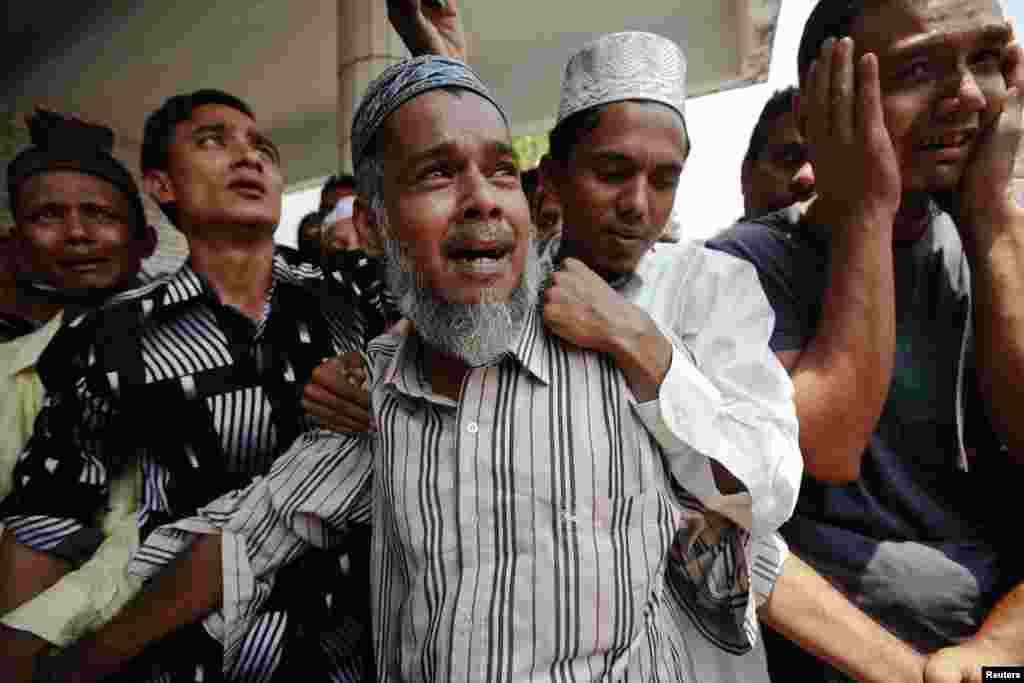 People react as the bodies of victims of a fire are brought for their funeral at Yaeway cemetery in Rangoon, Burma. Thousands of Muslims attended the funeral for the 13 victims of the fire that broke out in a dormitory of an Islamic school in Botataung district of the former capital. The fire caused by faulty electrical equipment, the fire service said.