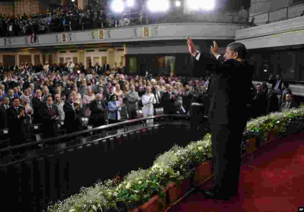 Egypt's newly inaugurated President Mohamed Morsi waves to a crowd assembled at Cairo University in Cairo, Egypt, Saturday, June 30, 2012.