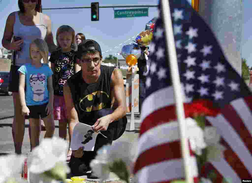 Isaac Pacheco leaves a birthday card for his friend Alex Sullivan, who was killed Denver-area movie killings, at a memorial site for victims behind the theater where a gunman opened fire on moviegoers in Aurora, Colorado July 21, 2012.